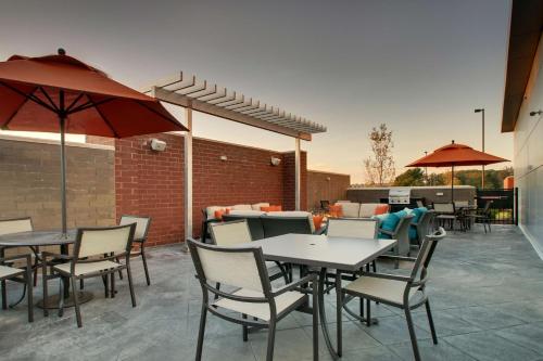 an outdoor patio with tables and chairs and umbrellas at Hyatt House Oak Brook in Oak Brook