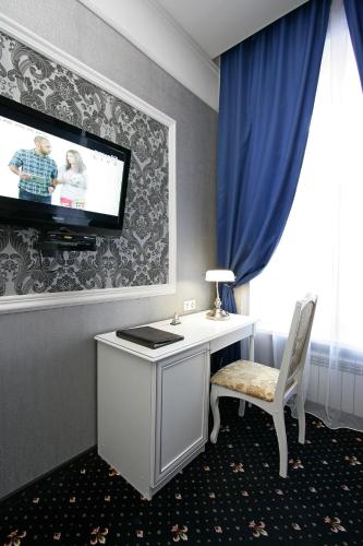 a room with a desk and a tv on a wall at Hotel Litera in Dnipro