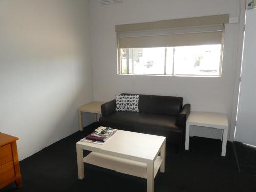 a living room with a couch and a table at Motel Wellington Wodonga in Wodonga