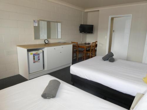 a room with two beds and a kitchen and a table at Motel Wellington Wodonga in Wodonga