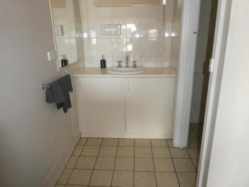 a bathroom with a sink and a tiled floor at Motel Wellington Wodonga in Wodonga