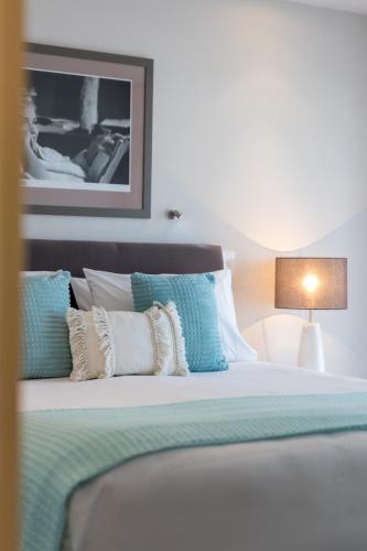 a bedroom with a bed with blue and white pillows at Century Park in Nelson