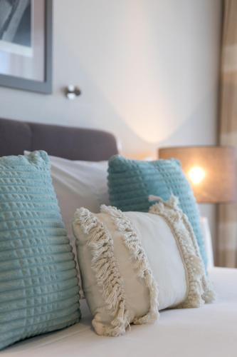 a group of pillows sitting on top of a bed at Century Park in Nelson