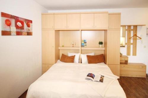 キュールングスボルンにあるStrandstrasse-43-Wohnung-14-896のベッドルーム1室(白い大型ベッド1台、本2冊付)