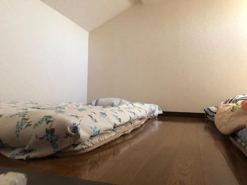 a room with two beds sitting on a wooden floor at 竜ヶ崎駅そばのゲストハウスM&M in Ryūgasaki