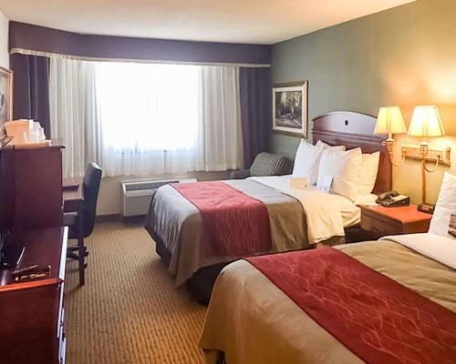 Habitación de hotel con 2 camas y escritorio en Comfort Inn, en Springfield