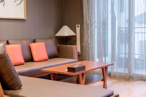 a living room with a couch and a coffee table at Oriens Hotel & Residences Myeongdong in Seoul