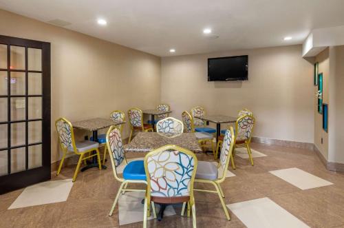 una sala d'attesa con tavoli e sedie e una TV a schermo piatto di Quality Inn Covington Downtown a Covington