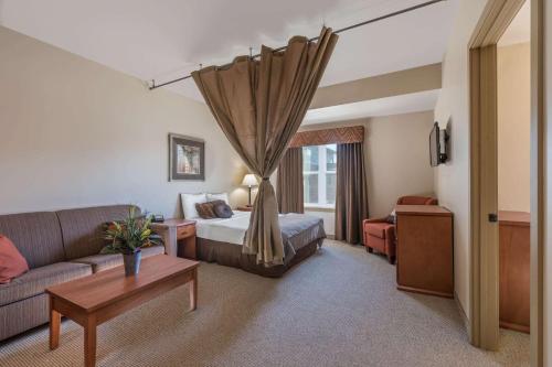ein Hotelzimmer mit einem Bett und einem Sofa in der Unterkunft Clarion Hotel & Suites Near Pioneer Power Generating Station in Williston
