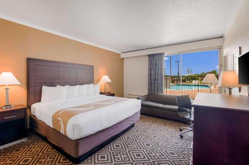 a hotel room with a bed and a desk and a chair at Quality Inn in Gastonia