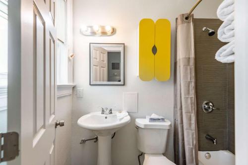 ein Badezimmer mit einem Waschbecken, einem WC und einem Spiegel in der Unterkunft Quality Inn & Suites Kansas City Downtown in Kansas City