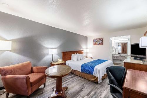 ein Hotelzimmer mit einem Bett und einem Stuhl in der Unterkunft Econo Lodge Phoenix North I-17 in Phoenix