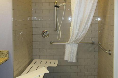 a shower with a bench and a shower curtain at Quality Inn & Suites in Caldwell