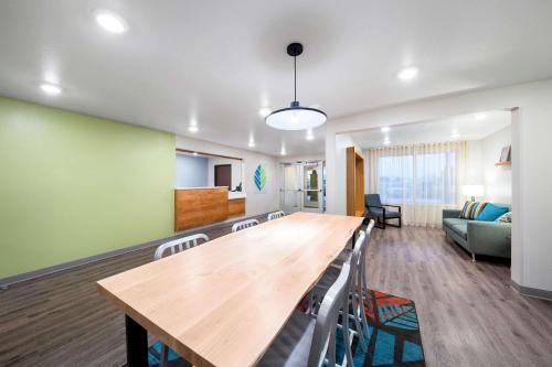a living room with a large wooden table and chairs at WoodSpring Suites Dallas Plano Central Legacy Drive in Plano