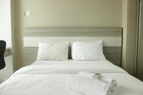 JatirokeComfy Studio Apartment near UNPAD Taman Melati Jatinangor By Travelio的一张铺着白色床单和毛巾的床