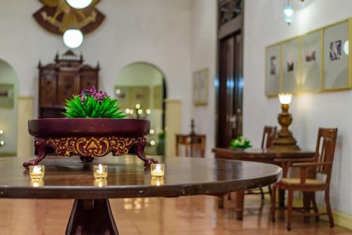 
a table topped with a vase filled with flowers at Hotel Tugu Blitar in Blitar
