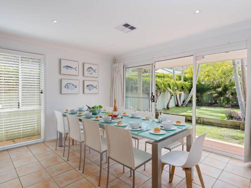 a dining room with a table and chairs at 8a Foreshore Drive Ducted Air and Boat Parking in Salamander Bay