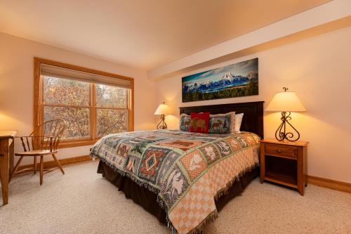 Schlafzimmer mit einem Bett, einem Schreibtisch und einem Fenster in der Unterkunft Targhee Rentals 414 Teton Creek Resort Driggs ID in Driggs