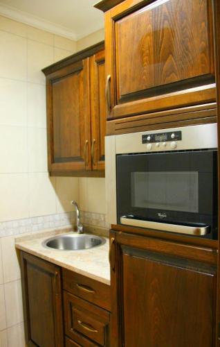 a kitchen with a sink and a microwave at Russian Pilgrim Residence in Sowayma
