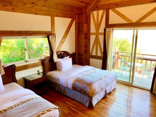 a bedroom with two beds in a room with windows at The Cotswolds Villa in Renai