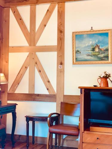 a room with a tv and a desk and a chair at The Cotswolds Villa in Renai