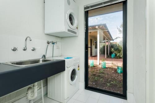 une cuisine avec un évier et une machine à laver dans l'établissement Cosy Corner by the BnB Collection, à Albany