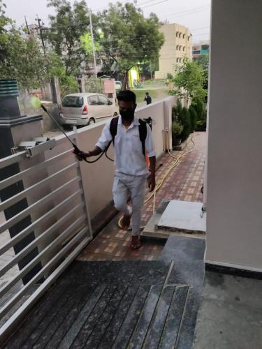 a man walking down a sidewalk with a spear at Hotel Sai Guest House in Nagpur
