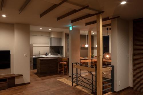 a kitchen and dining room with a table and a dining room at MOKUREN in Furano