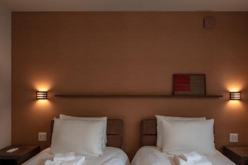 2 camas en una habitación con 2 luces en la pared en MOKUREN, en Furano