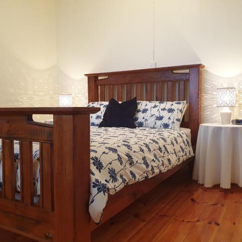 sypialnia z łóżkiem z drewnianą ramą i stołem w obiekcie Blue Seas - Beach Front Living w mieście Tumby Bay