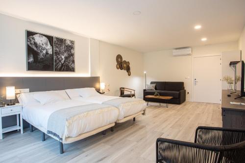 a bedroom with a large bed and a living room at Soraluze Hotela in Oñate