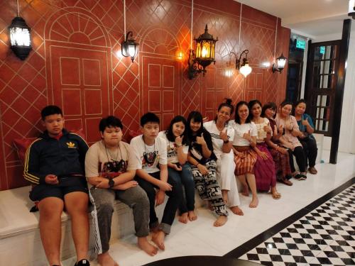 a group of people sitting on a line in a room at At Night in Chumphon