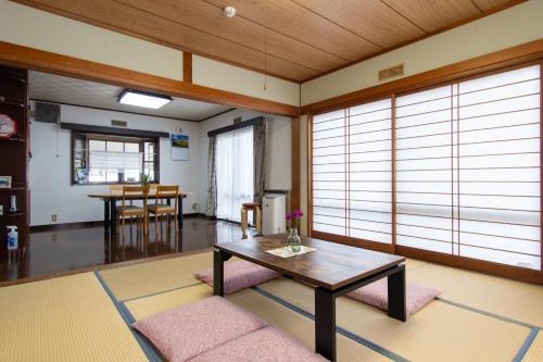 - un salon avec une table et quelques fenêtres dans l'établissement Guest house Fujinoyado Akebono - Vacation STAY 92428, à Fujiyoshida