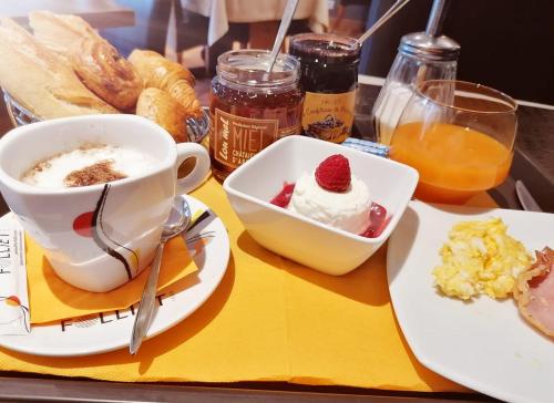 a tray with a cup of coffee and a plate of food at Logis Le Printemps Hôtel Restaurant - Montélimar in Montélimar