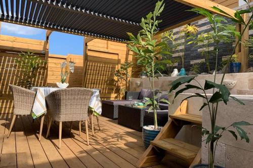 a patio with a table and chairs on a deck at VILLA LORET in Étang-Salé