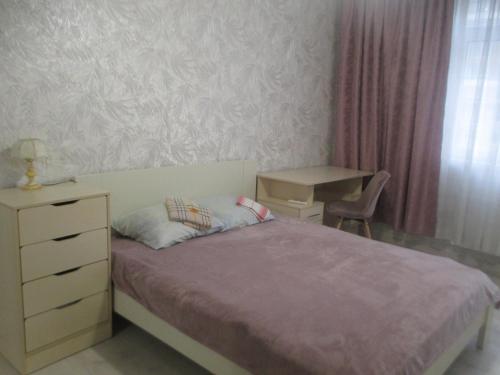 een slaapkamer met een bed, een dressoir en een stoel bij проспект Правды 41-е in Kiev