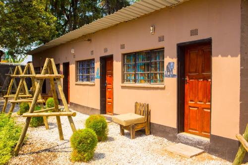 a house with wooden doors and a chair in front of it at Lusaka Backpackers in Lusaka