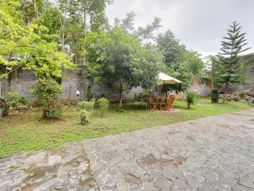 a patio with a table and a umbrella in a yard at Urbanview Hotel Bergas Indah Bandungan by RedDoorz in Bandungan