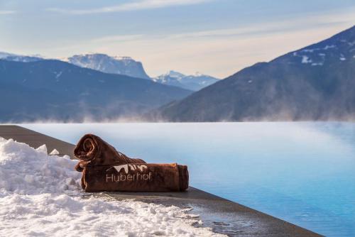 a hot dog sitting in the snow next to a lake at Panoramahotel Huberhof in Maranza