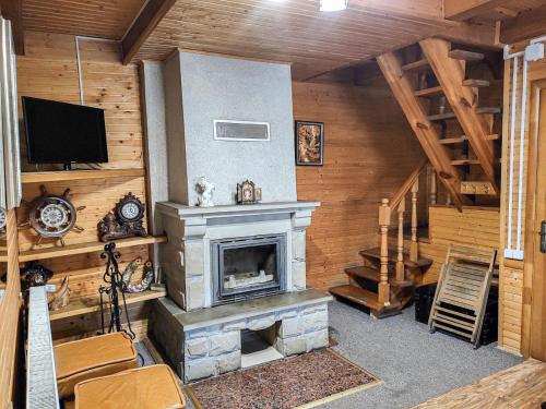 a living room with a fireplace and a tv at Котедж Синя гора in Bukovel