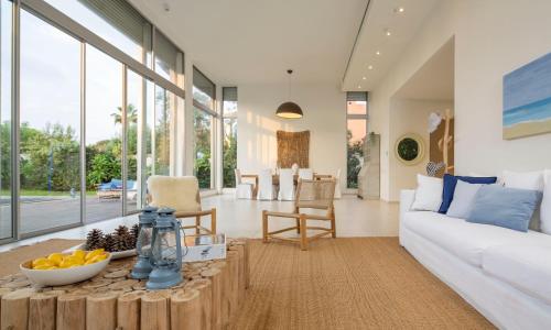 a living room with a white couch and a table at Beach House Galei in Herzliya B
