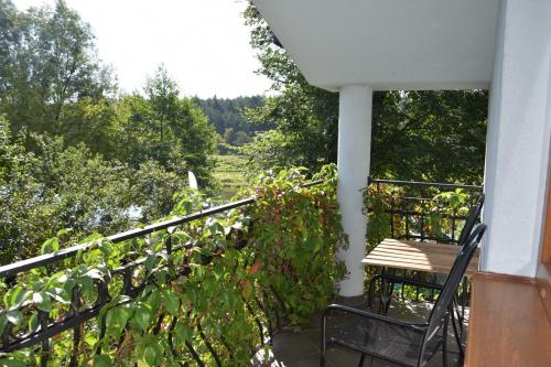 a chair sitting on a balcony with a view at Willa Amber Zakościele in Inowłódz