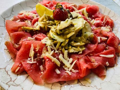 a plate of food with watermelon and cheese at Impero Hotel Beauty & Spa - Bike Hotel in Cantello