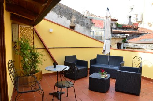 a balcony with chairs and a table and an umbrella at Archubintu B&B in Sassari