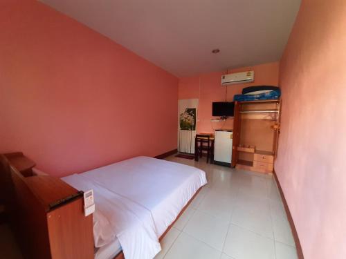 a small bedroom with a bed and a table at Khuang Na Farmview in Ban Tambon Bang Khae