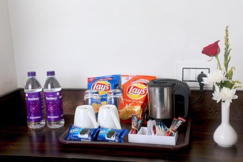 a tray with toothbrushes toothpaste and drinks on a table at Hotel Planet Four in Lonavala