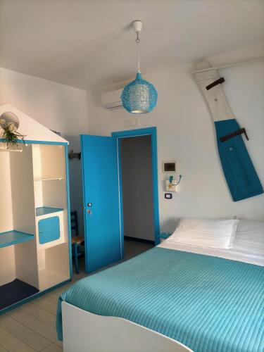 a bedroom with a blue bed and a blue door at ControVento Rooms in Margherita di Savoia