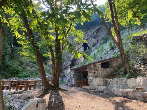 a stone cabin with a tree and a bench at Impero Hotel Beauty & Spa - Bike Hotel in Cantello