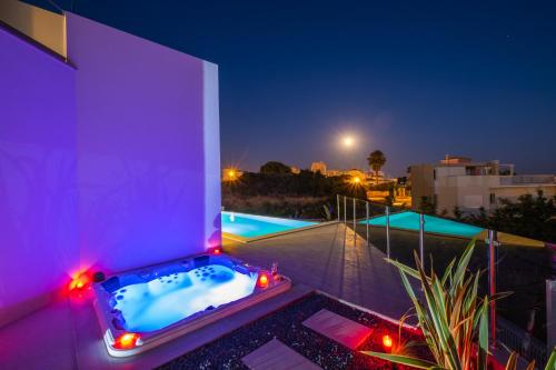 een hot tub op het dak van een huis 's nachts bij Villa Charlotte by Algarve Vacation in Armação de Pêra