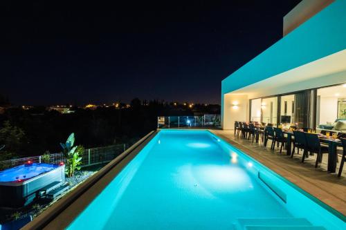a swimming pool on the roof of a house at night at Villa Charlotte by Algarve Vacation in Armação de Pêra